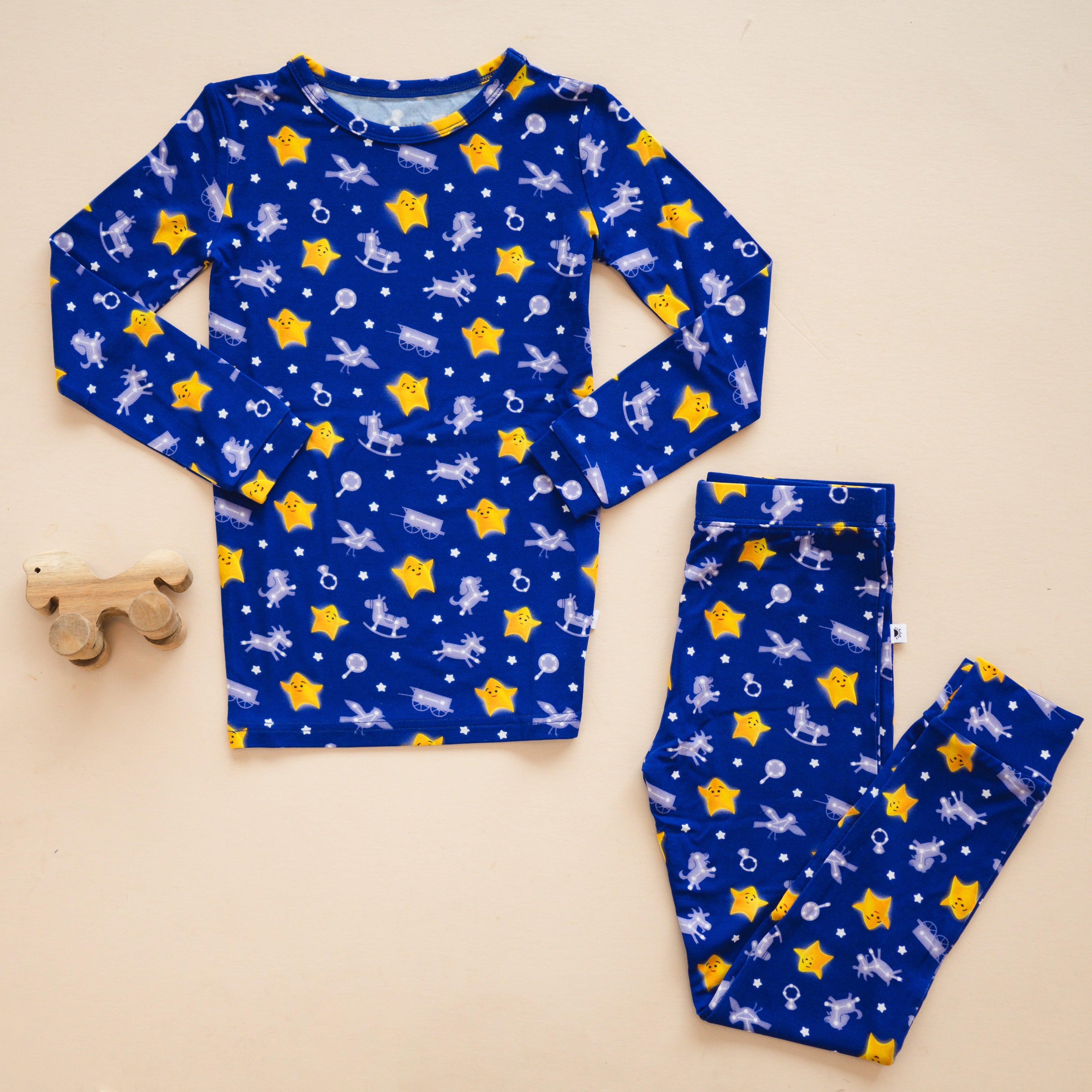 Blue pajama set with yellow stars and white toy patterns.