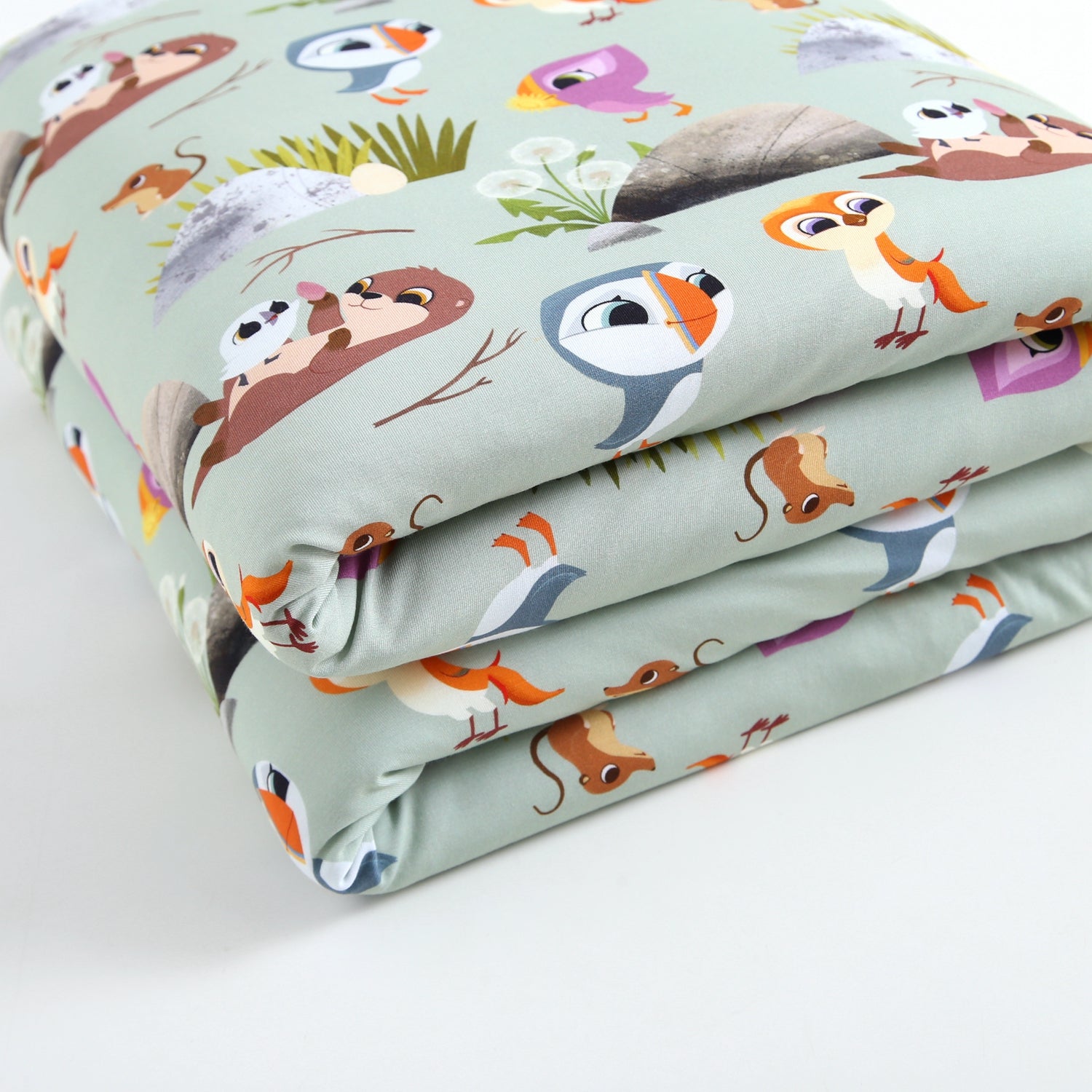 A light green fabric with a Puffin Rock™ print featuring various cartoon animals.