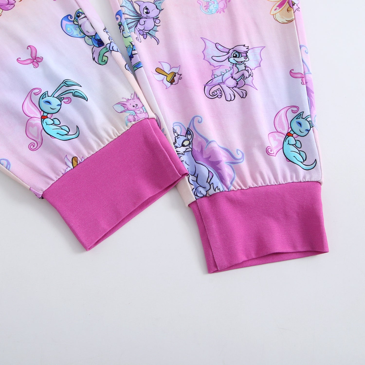 Pink joggers with Neopets faerie print and purple cuffs.