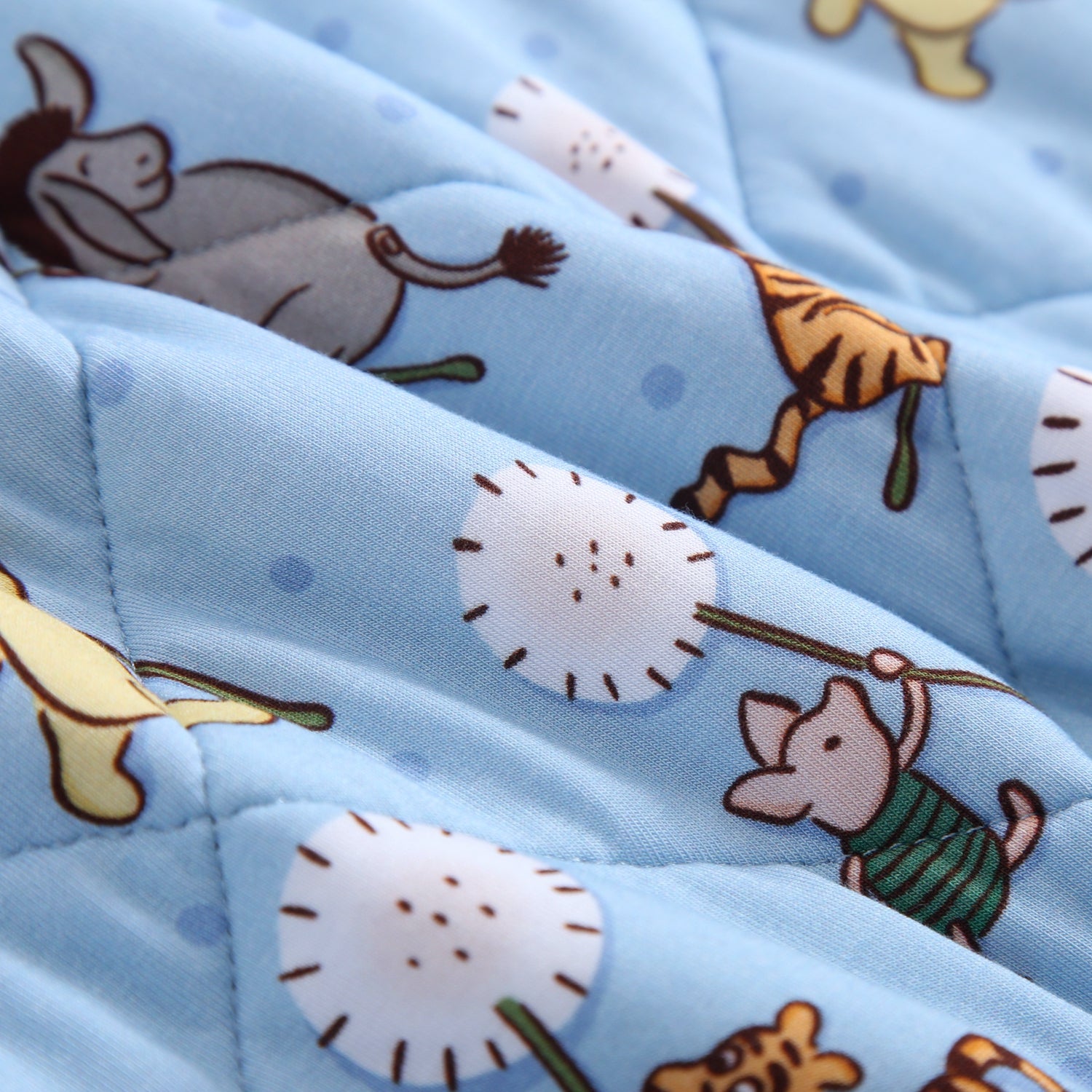 A light blue quilted blanket with a pattern