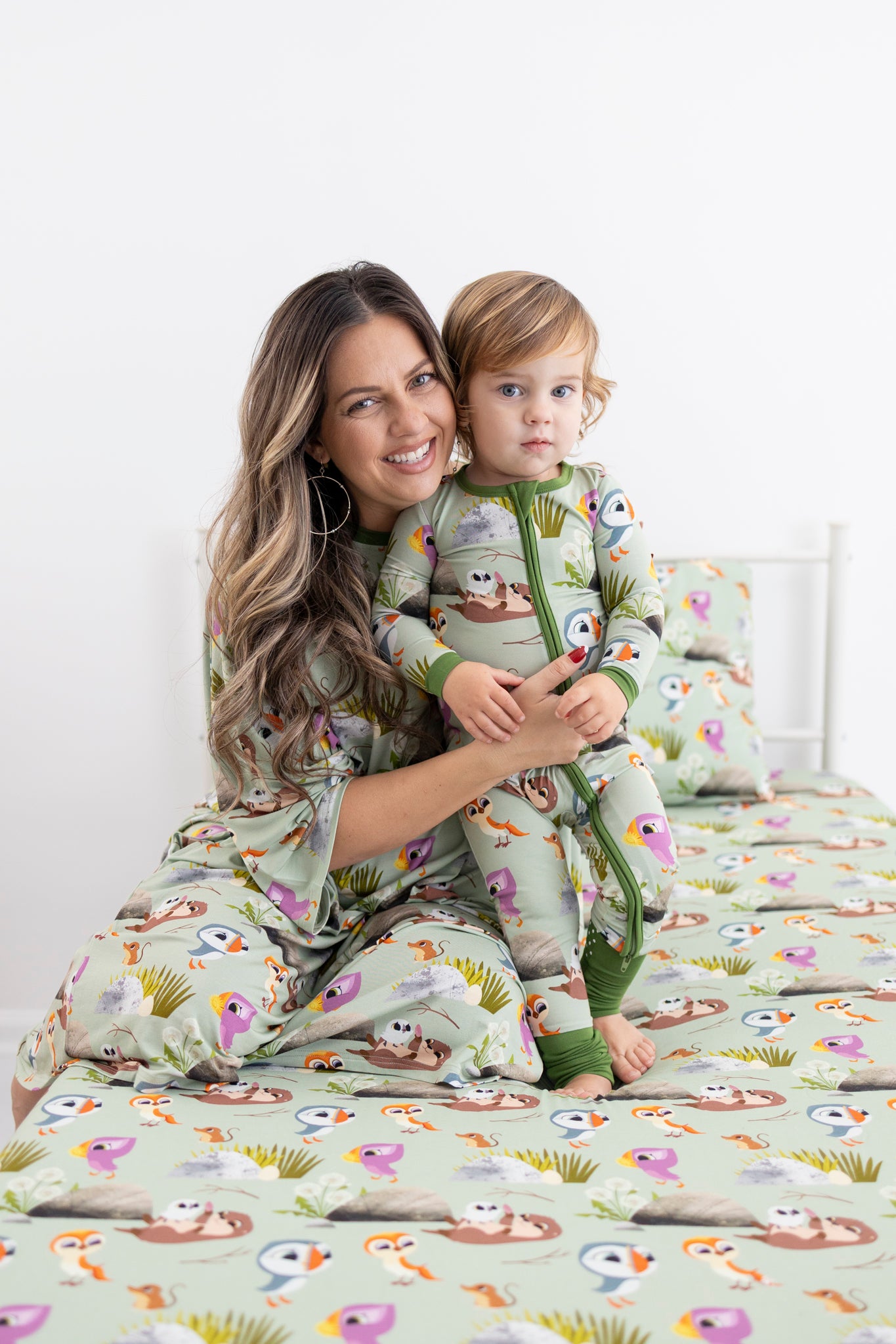 A woman and child in matching green pajamas with a Puffin Rock print.