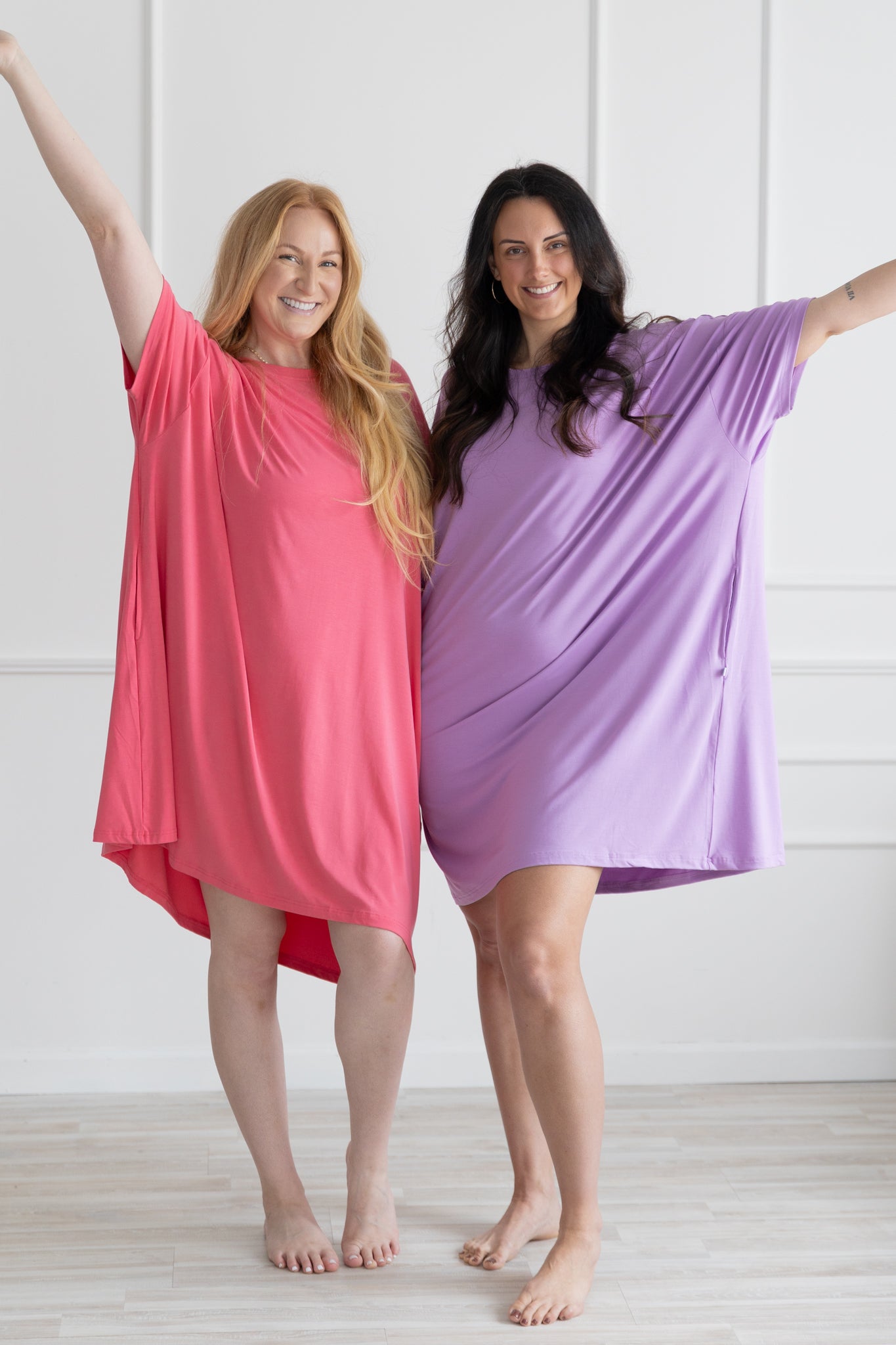 Two women wearing loose-fitting, short-sleeved Tencel modal sleep tees in pink and purple.