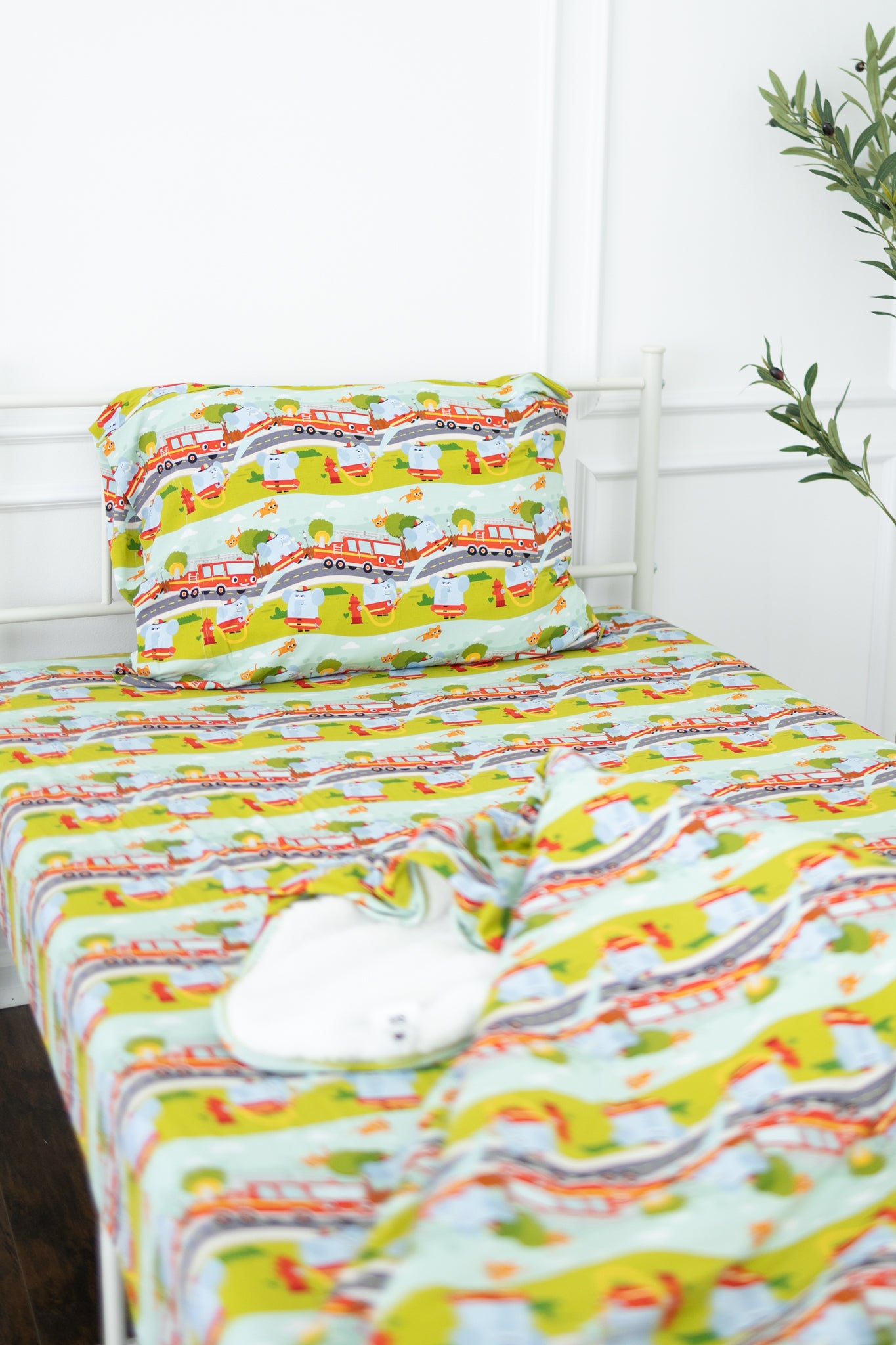 A twin-sized fitted sheet and pillowcase set featuring a colorful firetruck and road pattern.