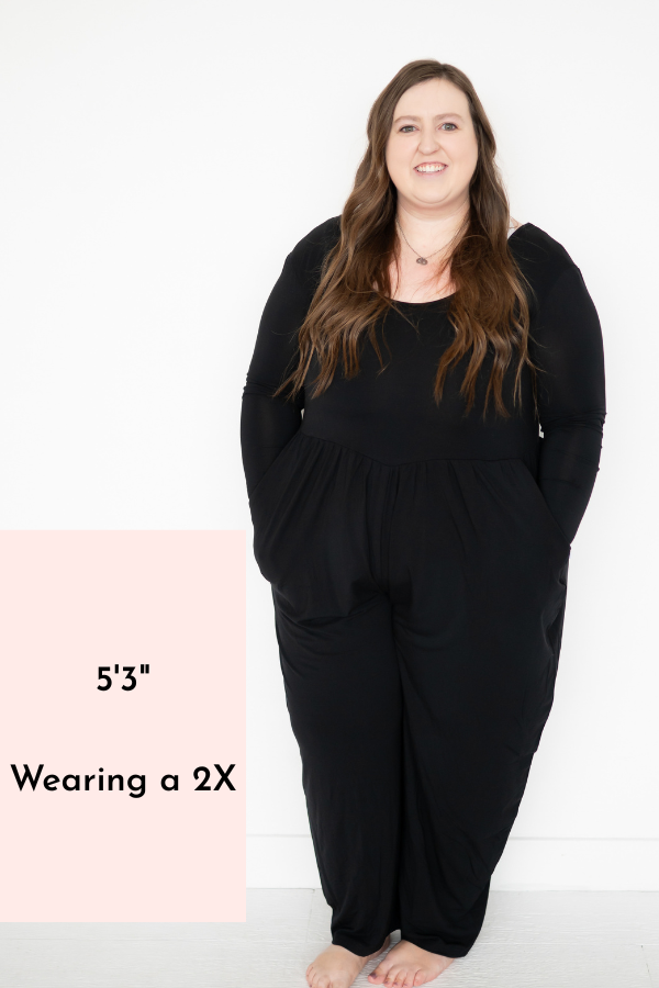 Long sleeve black Tencel Modal romper with a scoop neckline and pockets on a woman.