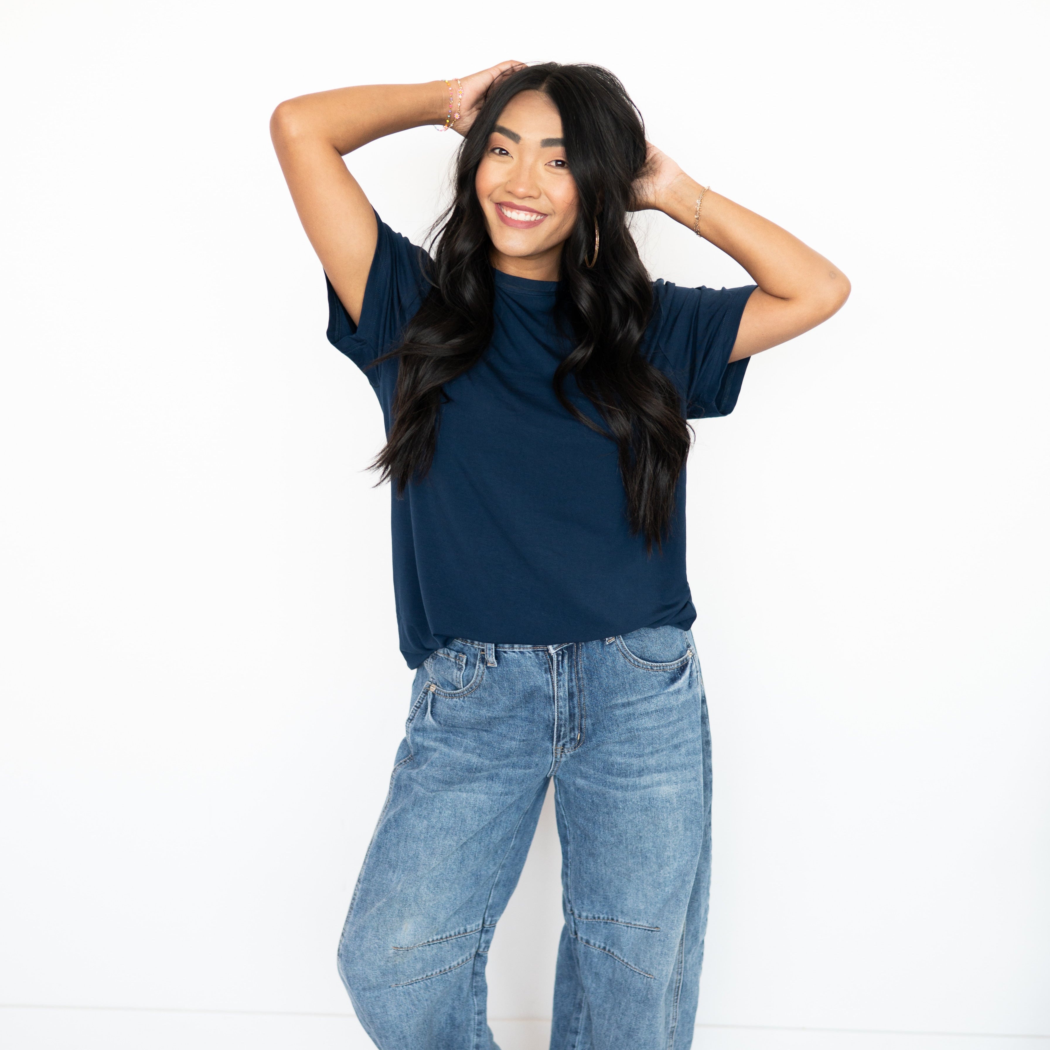 Woman wearing an oversized navy bamboo t-shirt and blue jeans.