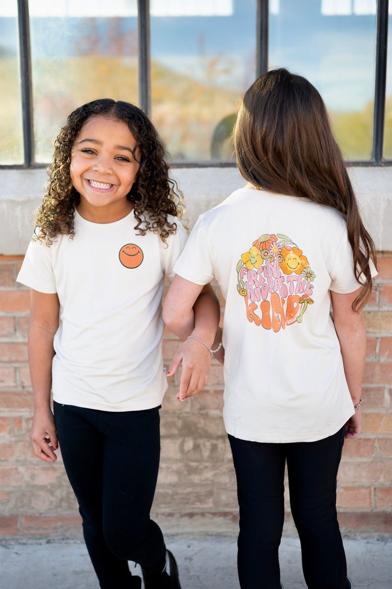 Cream t-shirt with smiley face graphic on front and floral smiley graphic on back.