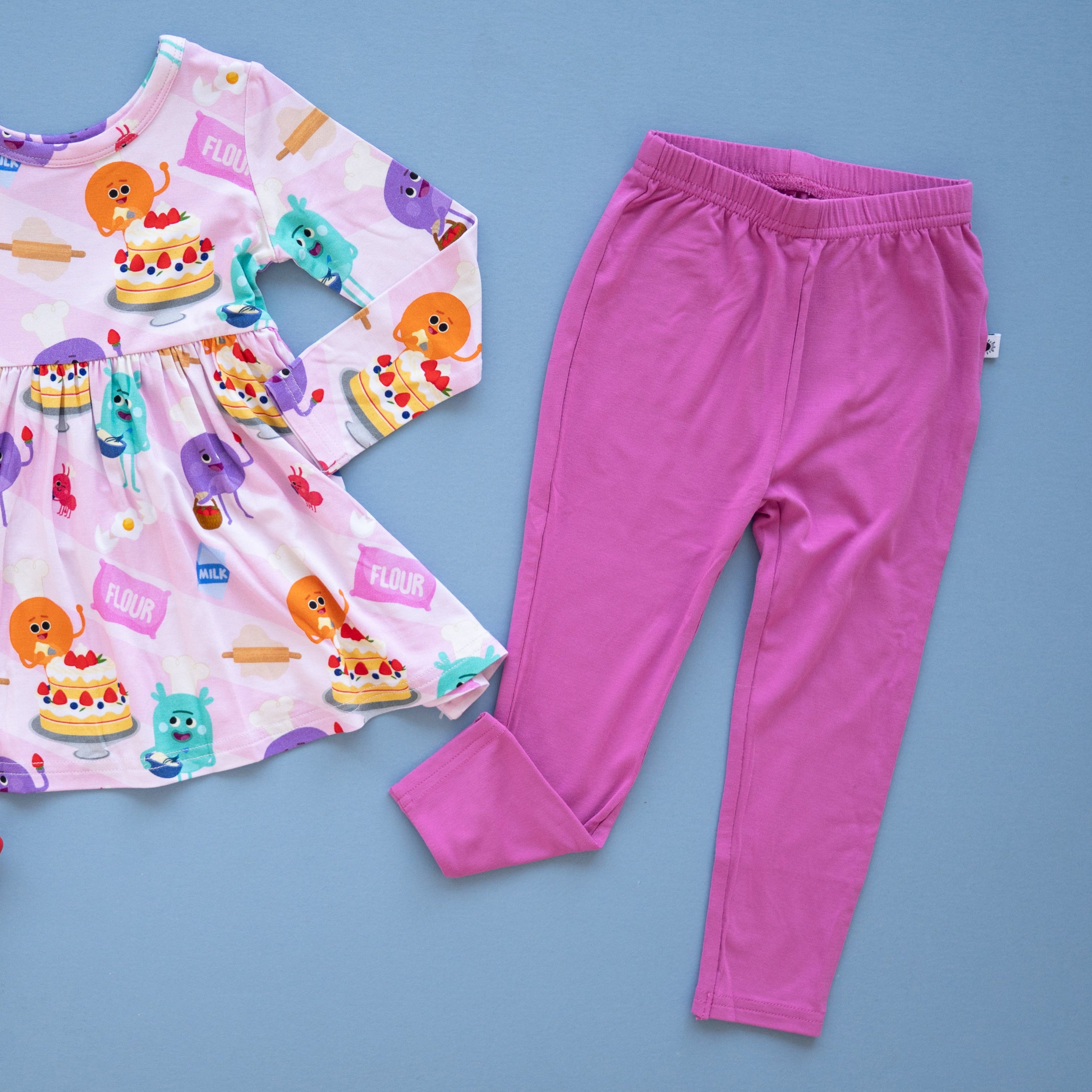 Pink leggings with a ruffled waistband and a small white tag.