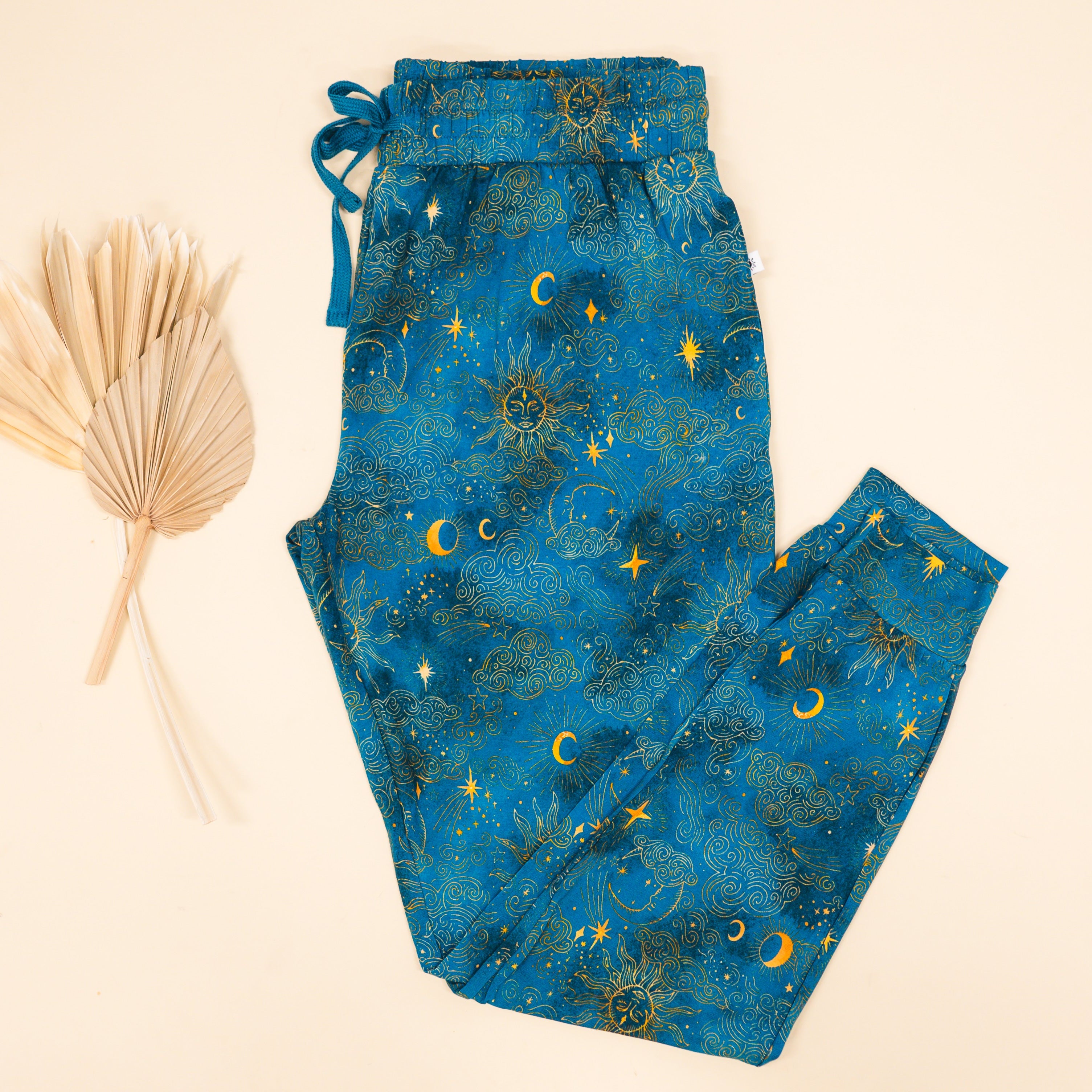 Women's blue joggers with a celestial sun, moon, and star print.