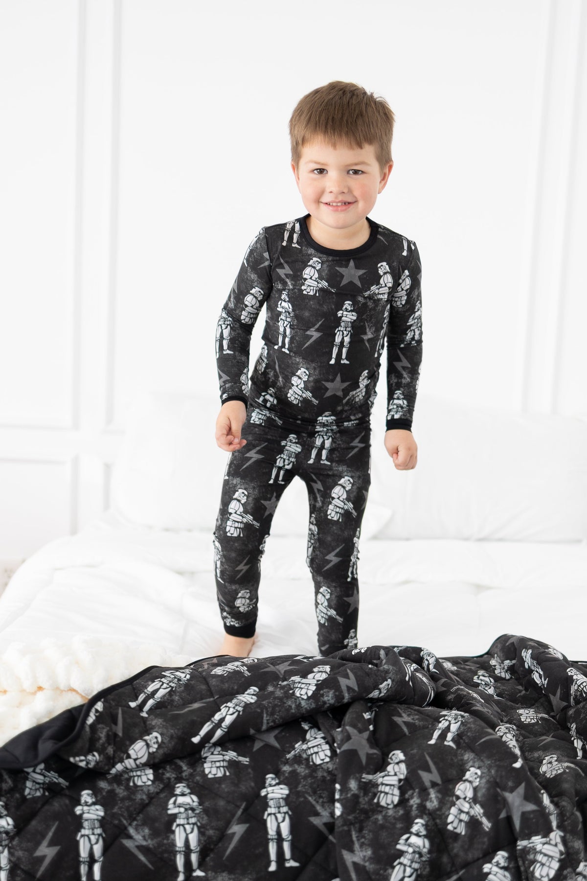 Boy in black pajamas with white stormtrooper print.