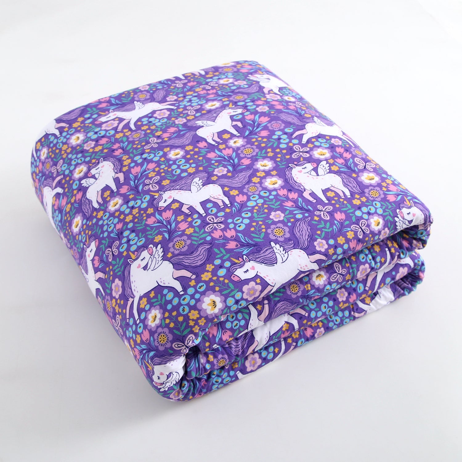 A purple plushy with a unicorn and floral print.