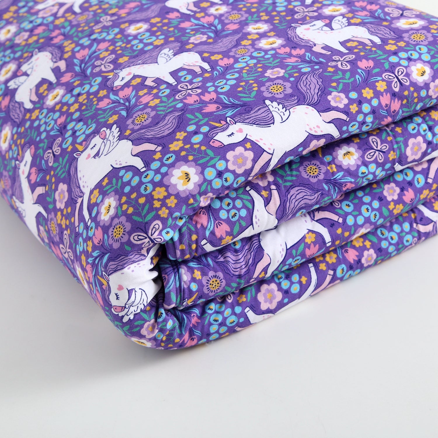 A purple fabric with a unicorn and floral print.
