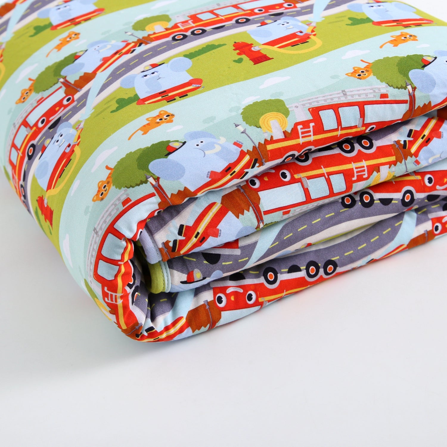 Rolled fabric with a playful firetruck and elephant print.