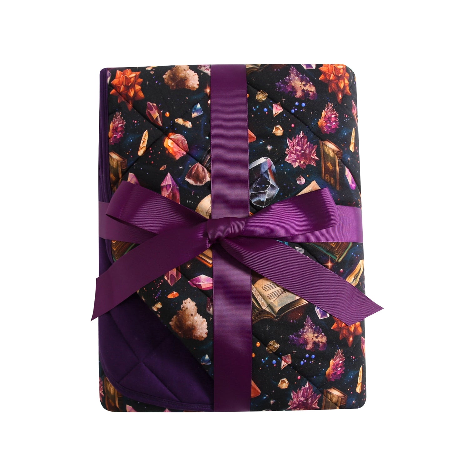 A quilted couch quilty with a crystal and book pattern, tied with a purple ribbon.