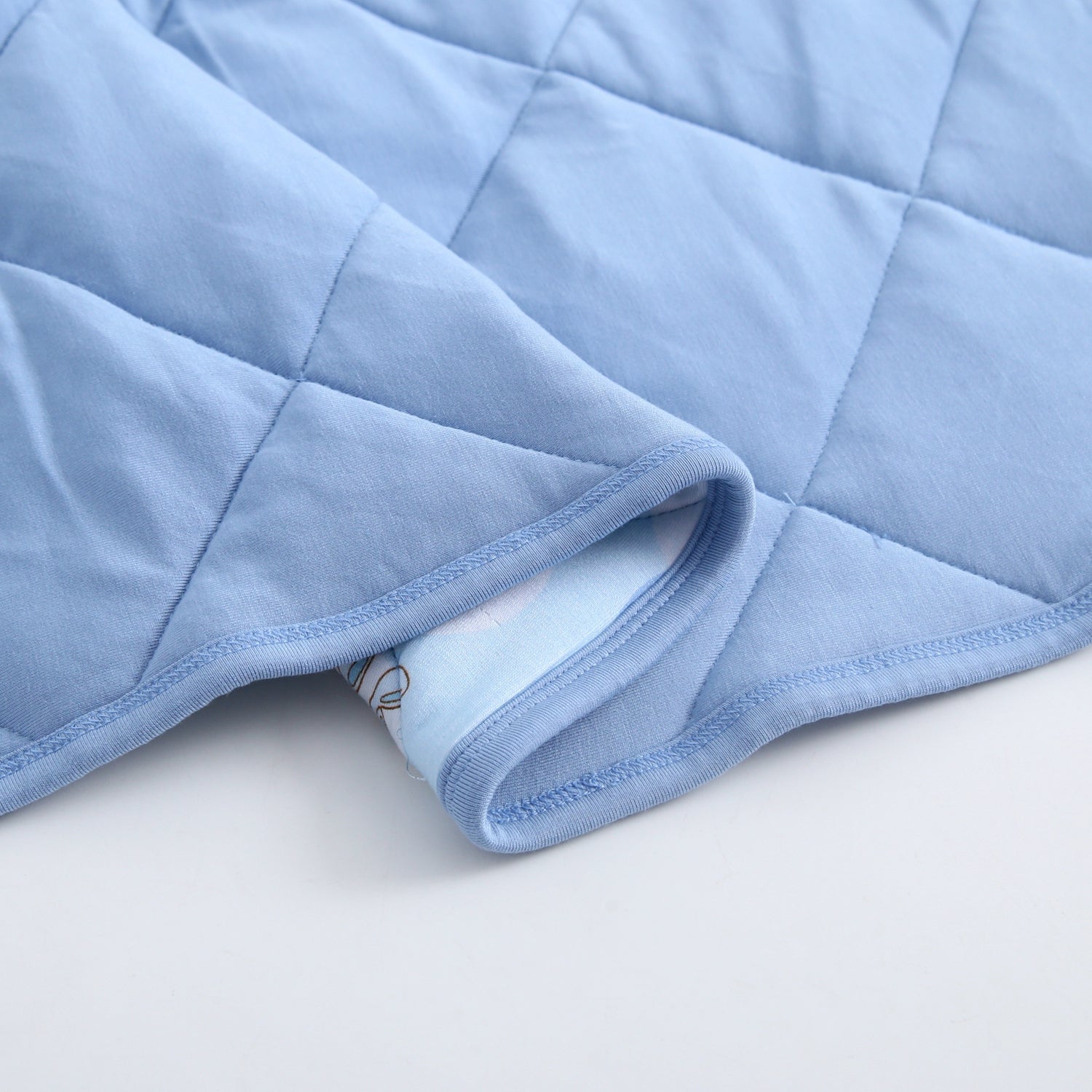 A light blue quilted blanket with a patterned edge.