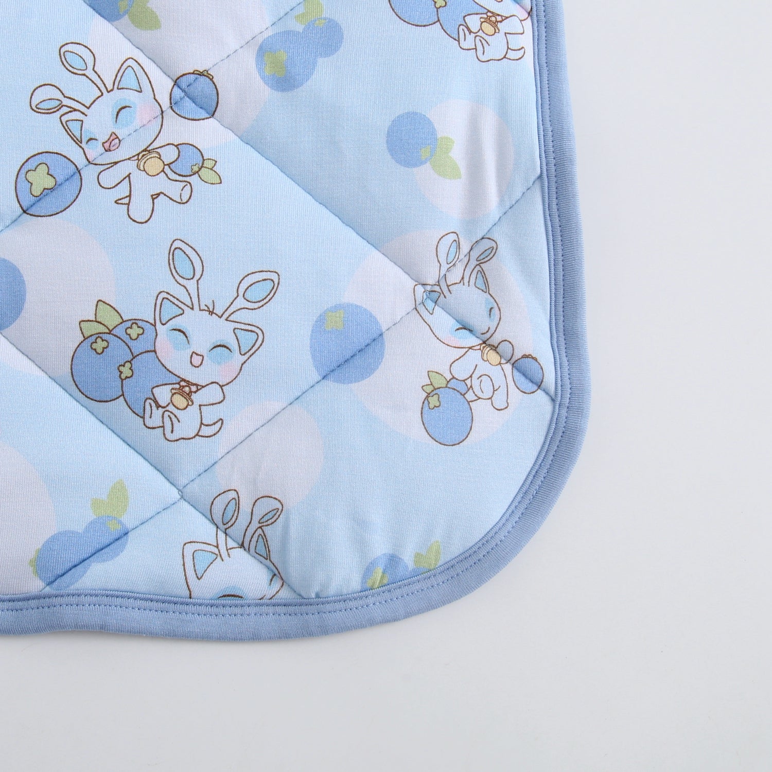 A light blue quilted blanket with a Neopets Blueberry Baby Aisha pattern.