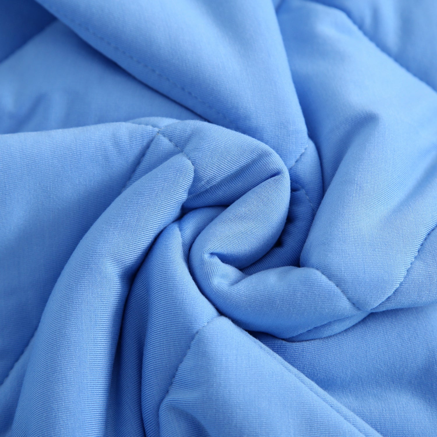 A blue quilted blanket with a swirled pattern.