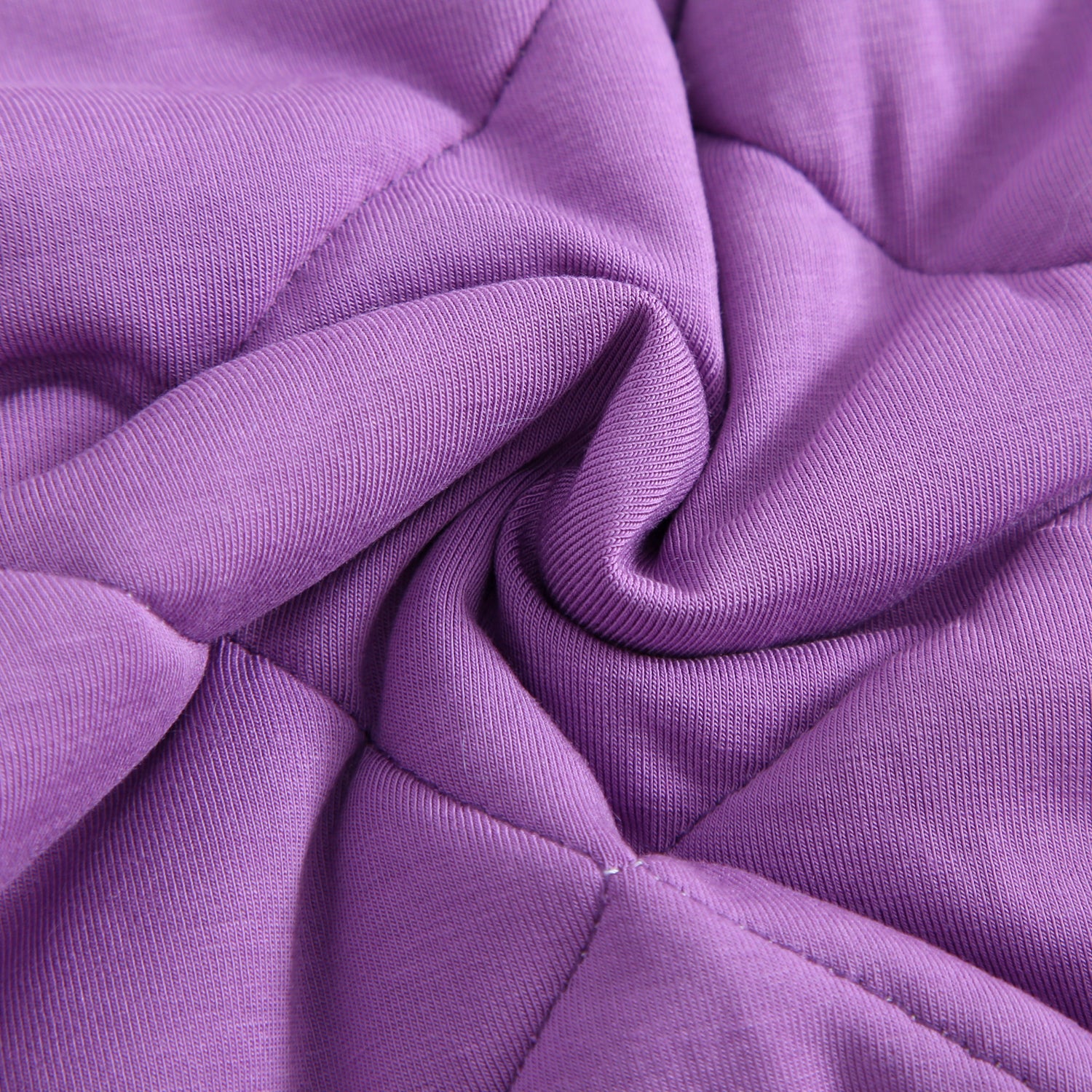A close-up of a soft, quilted purple bamboo fabric with visible stitching.
