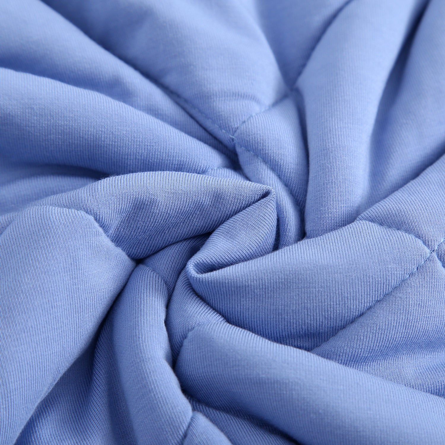 Quilted blue fabric with a swirled pattern.