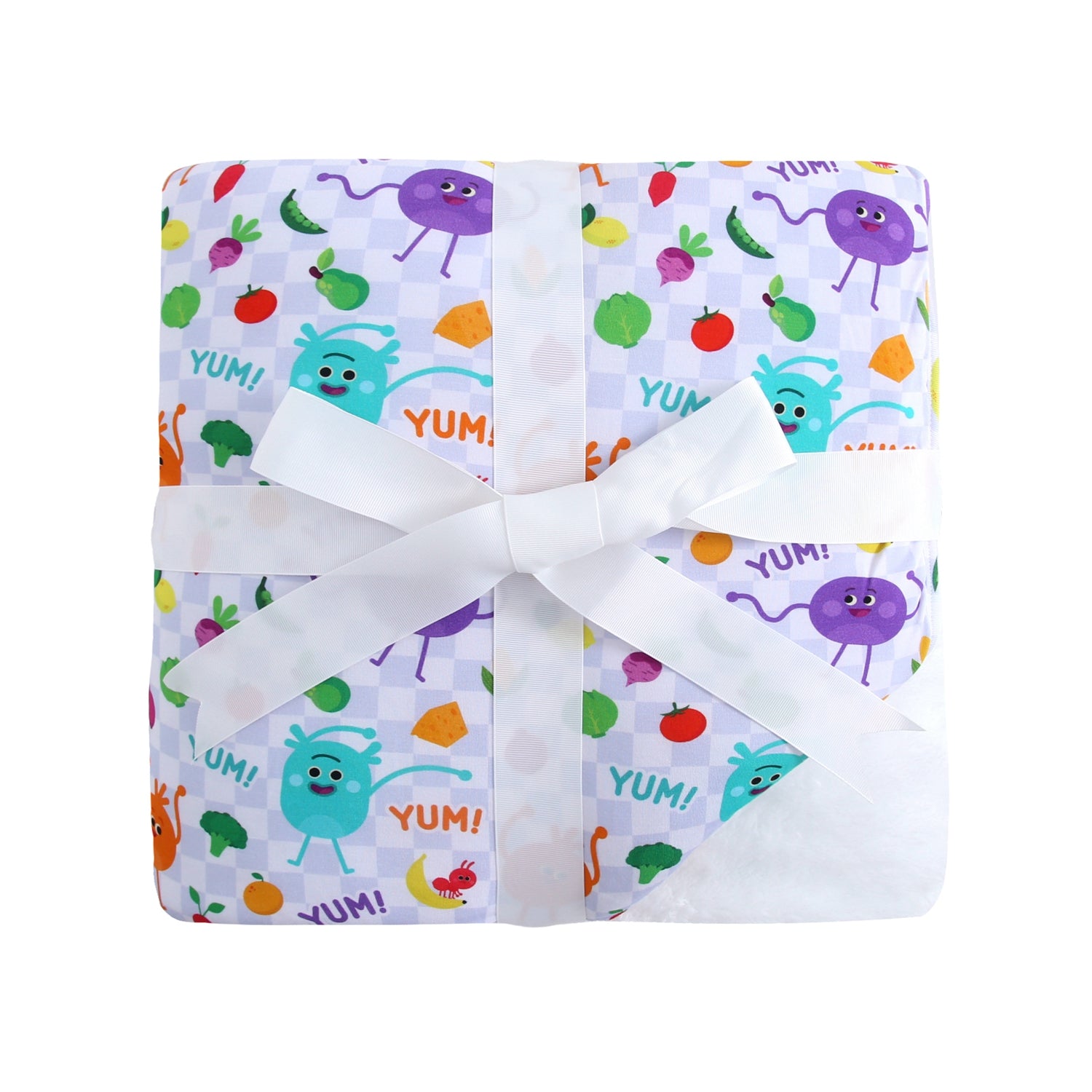 A plush blanket with a colorful pattern of cartoon vegetables and the word "YUM".
