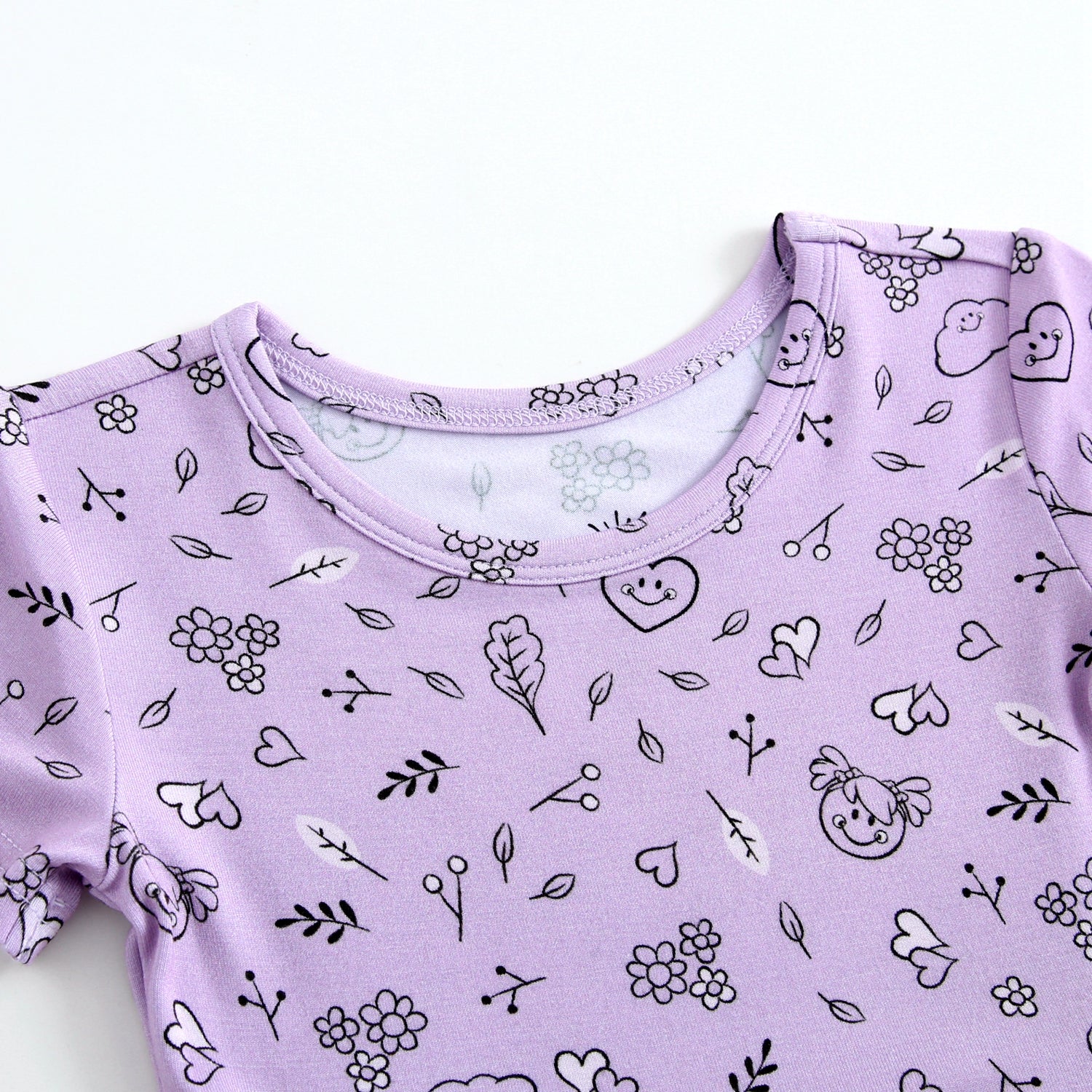 Lilac bamboo dress with a playful doodle print of flowers, hearts, and smiley faces.