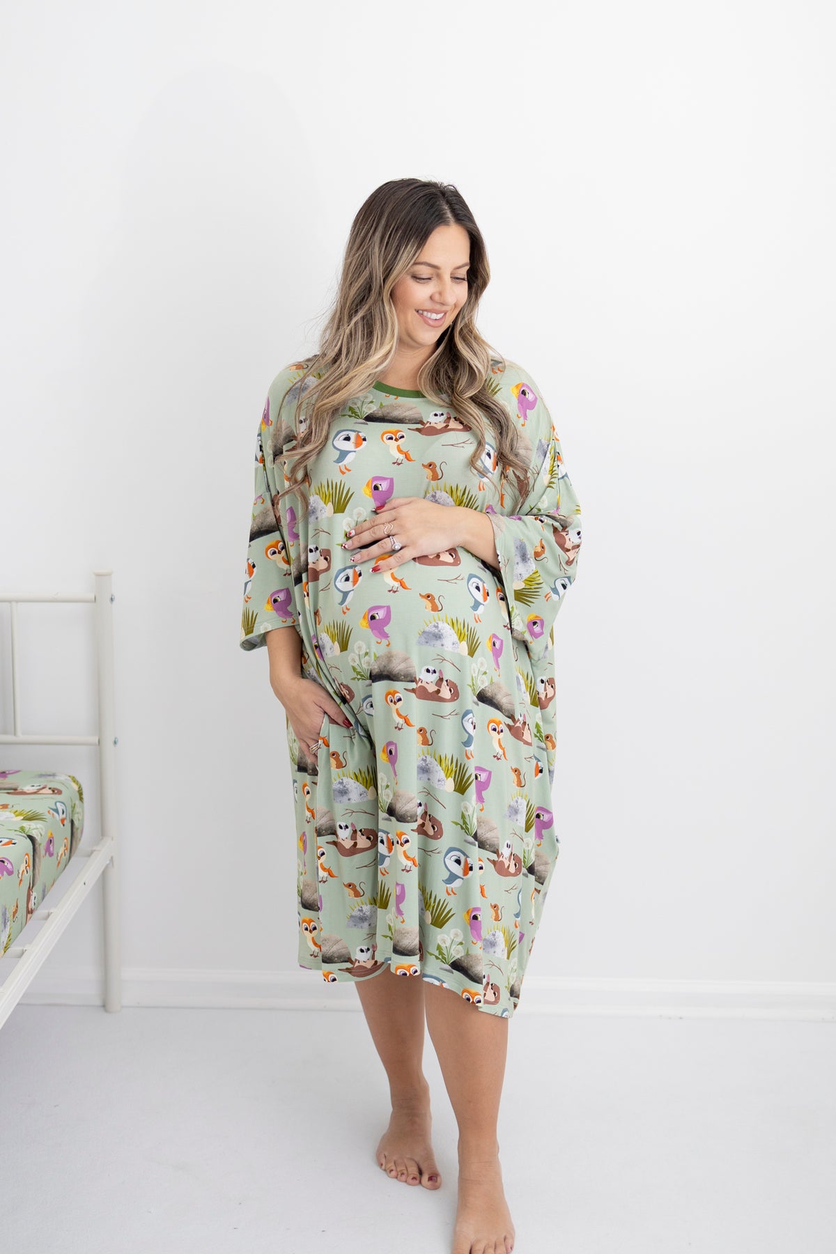 A pregnant woman wears a light green Tencel modal sleep tee with a Puffin Rock print.