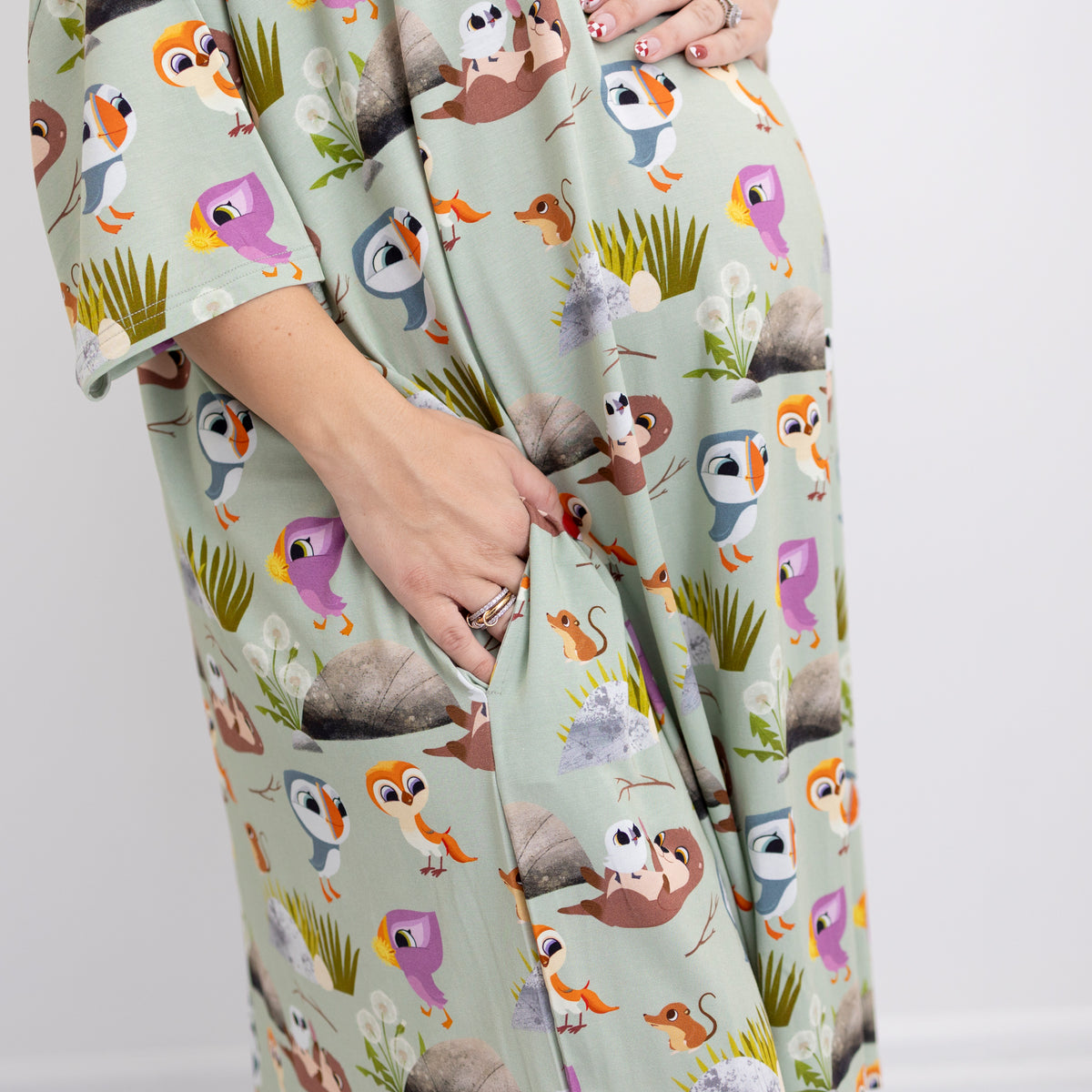 A light green sleep tee with a Puffin Rock™ character print, featuring a hand in the pocket.