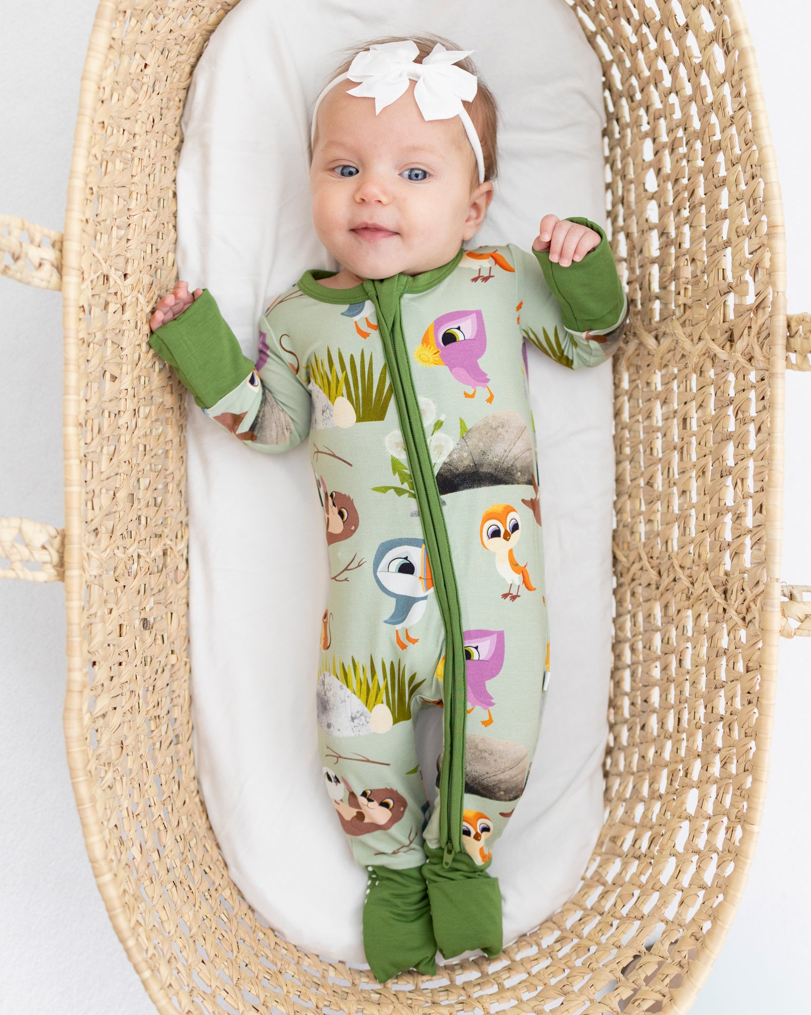 Baby in a green Puffin Rock™ themed Tencel™ Modal zip pajama.