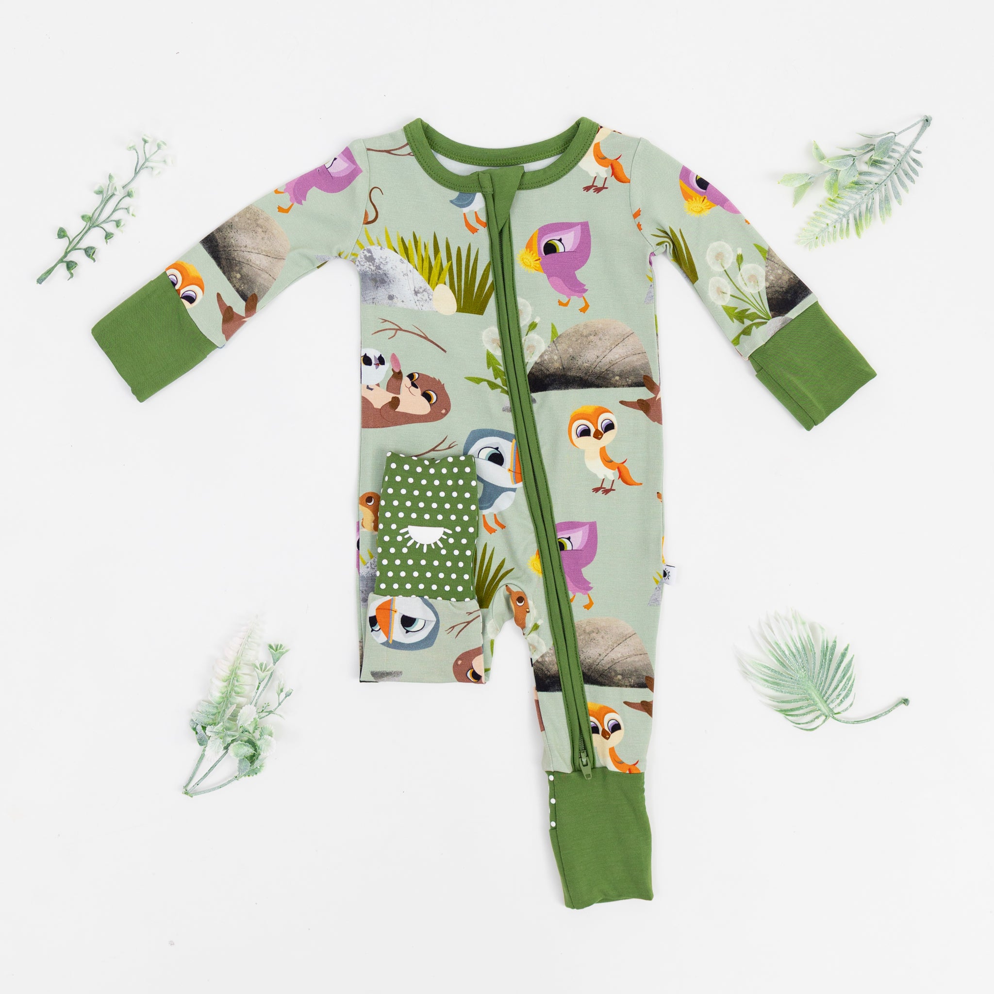 A light green baby pajama set with a Puffin Rock print and green trim.