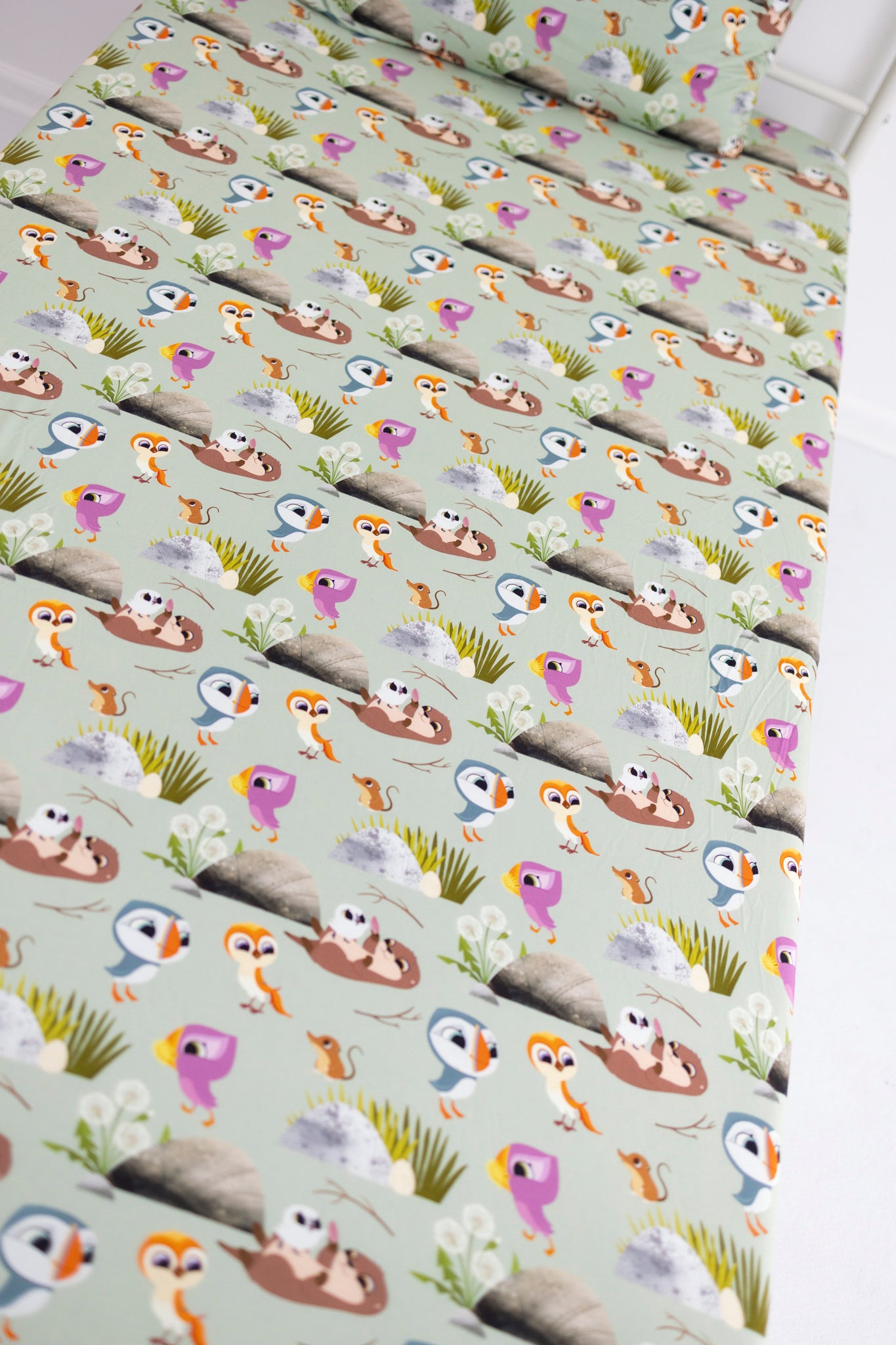 A light green twin sheet and pillowcase set with a Puffin Rock™ pattern.