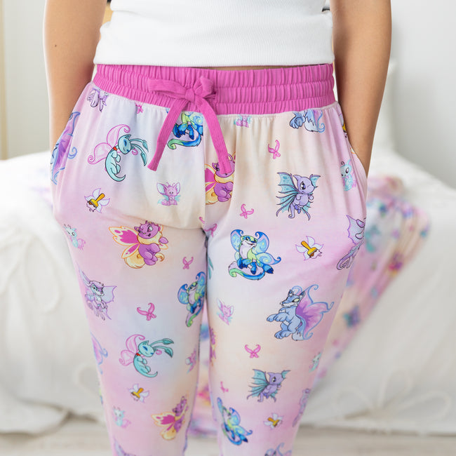 Women's jogger pants featuring a colorful Neopets Faerie print on a pink and white gradient.